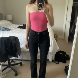 Rosa body  tubtopp från Urban Outfitters - Säljer en snygg rosa body tubtopp från Urban Outfitters. Toppen är ribbad och har en tight passform som sitter perfekt på kroppen. Helt ny storlek M