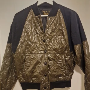 Quiltad bomberjacka från MET  - Snygg bomberjacka från det italienska märket MET i olivgrönt och svart. Tvättad vid flytt endast. Dyr vid inköp. 
