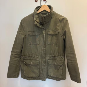 Olivgrön parkajacka från Samsøe Samsøe - Parkajacka i olivgrön färg från Samsøe Samsøe med hög krage. Perfekt snygg jacka inför hösten. Se bilder för skick. Jackan skickas samma dag eller dan efter. Hör gärna av dig om du har frågor eller funderingar.