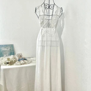 Vit lång klänning med spetsdetaljer  - Vit lång klänning / nattlinne med spetsdetaljer framtill och snöret på baksidan för att justera storleken. Passar bäst storlek 34-36. Dockan har storlek 34. 