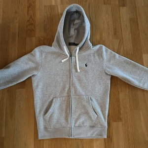 Grå hoodie från Polo Ralph Lauren - Säljer en riktigt najs Ralph Lauren Hoodie t storlek L. Skick 9/10. Hör av er vid funderingar.