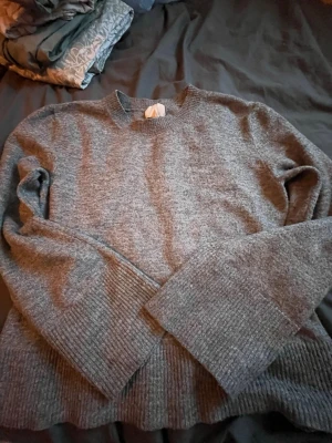 Grå stickad tröja  - Säljer en grå stickad tröja från H&M som inte kommer till användning hos mig! Tröjan är i bra skick och har inga skador. storlek M. Skriv vid frågor eller vid behov av fler bilder💞