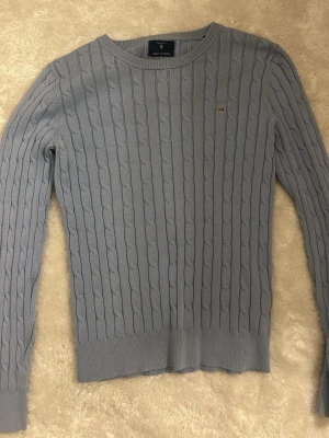 Ljusblå kabelstickad tröja från Gant - Fin stickad tröja från gant i ljus blå. Har inget synligt slitage och är i bra skick. 