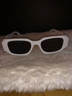 Prad Glasögon  - Säljer ett par supertrendiga vita Prada-glasögon! 🤍 Dessa solglasögon är det perfekta sättet att addera en touch av lyx och stil till vilken outfit som helst. De är inte bara snygga utan ger också ett utmärkt skydd. Perfekt för både vardag och speciella tillfällen. ✨ 🕶️