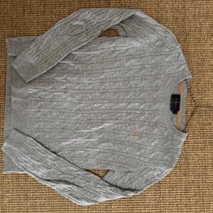 Kabelstickad Morris tröja - Säljer en jättesnygg grå tröja från Morris. Tröjan är kabelstickad och i storlek S. Materialet är Pima bomull vilket är en av de mjukaste bomullssorterna i världen. Nypris ca 1500 kr, säljer för 450, pris går att diskuteras