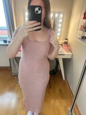 Rosa stickad klänning  - Rosa stickad klänning i mjukt material ocb ny skick. Inte använt denna kläng nån gång. Den har en liten slits på sidan av benet och är väldigt fin när man ska ut. Lite uringad. Storlek M