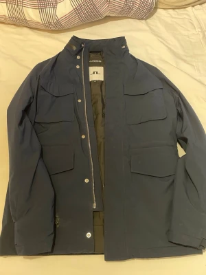 J.Lindeberg jacka  - Säljer denna jacka då den har blivit för liten för mig. Jackan har tyvär ett litet hål då det är lätt att fixa om du har någon kunnig som du känner som kan sy eller så kan man tejpa det där lilla hålet. Jackan är extrem varm och snygg skriv för frågor😊