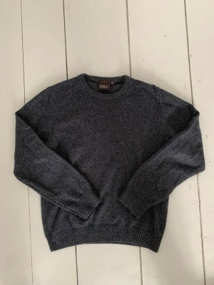 Mörkgrå stickad tröja Oscar Jacobson - Säljer en mörkgrå stickad tröja från Oscar Jacobson, tillverkad i Italien. Tröjan har rund hals, ribbade muddar och är långärmad. Perfekt för dig som gillar klassisk och enkel stil med premiumkänsla.