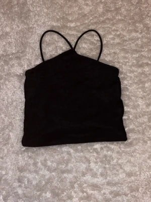 Svart ribbad linnetopp med smala band stl M - Säljer en svart linnetopp med smala axelband och ribbad struktur från ginatricot, använd fåtal gånger, köparen betalar frakt☺️