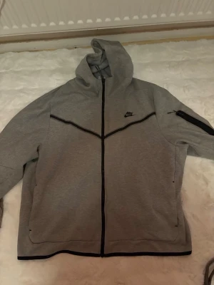 Grå Nike tech zip up - Väldigt snygg och bra Nike tech zip up. Använd några gånger men ser ut som ny!