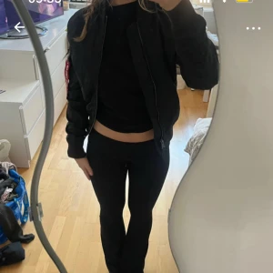 Svart bomberjacka från Alpha Industries - Säljer en svart bomberjacka från Alpha Industries med klassisk orange insida, guldfärgad dragkedja och ikonisk röd tag på ärmen. Jackan har ribbade muddar, fickor med lock och är tillverkad i glansig polyester. Köpt på Zalando.se för 1845 kr 