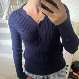 Marinblå ribbad kofta med knappar - Säljer en marinblå ribbad kofta med långa ärmar och knäppning framtill. Aldrig använd!