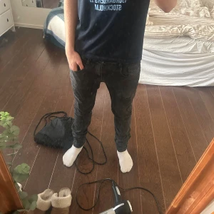 Svarta Replay Anbass Hyperflex jeans - Säljer ett par svarta Replay Anbass Hyperflex jeans i storlek 33. Jeansen har en slim passform med smala ben och är tillverkade i stretchigt material för extra komfort. En defekt vid fickan men annars inget annat, skriv vid frågor!