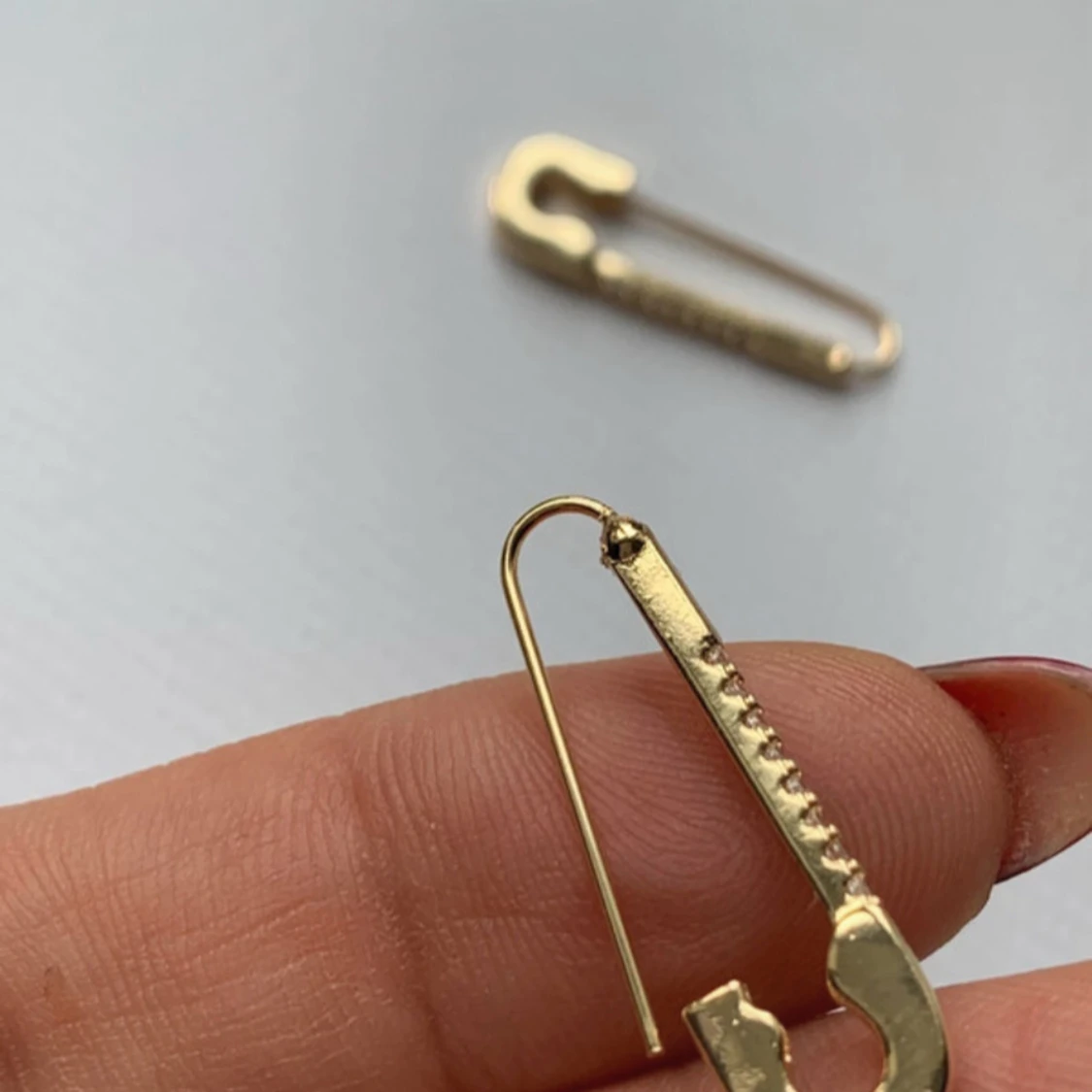 Guldiga örhängen med strass i säkerhetsnålform