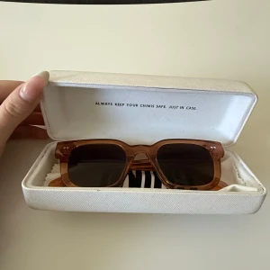 Chimi solglasögon peachfärgade - Snygga solglasögon från Chimi i modellen #004, med fyrkantig form och transparent peachfärgad båge. Glasen är mörka och ramen är i plast, vilket ger en modern och trendig vibe. Kommer med originaletui från Chimi.