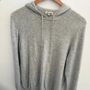 Soft goat Kashmir hoddie - Supermjuk och lyxig grå hoodie från Soft Goat i 100% kashmir. Skicket är bra förutom att den har ett lagat hål i ena armen se bild 5. Nypris ligger på 3600kr mittpris 1200 pga av de lagde hålet. Bara att skriva vid funderingar mvh Liam!