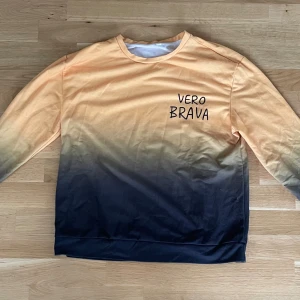 Ombre sweatshirt från Vero Brava - Cool sweatshirt från Vero Brava i ombre-färg från ljus orange upptill till svart nedtill. Tröjan har rund halsringning och långa ärmar. Perfekt för dig som vill sticka ut med en unik färgövergång. Skön och mjuk i bomullsmaterial.