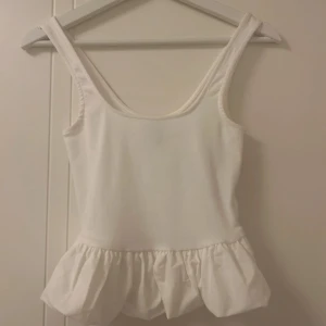 Vit ärmlös linnetopp med volang - Supersöt vit linnetopp med volang nertill. såå söt, skriv om du har några frågor💗