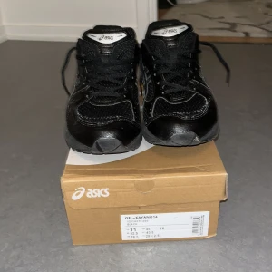 Svarta Asics Gel-Kayano 14 sneakers - Säljer ett par svarta Asics Gel-Kayano 14 sneakers med silvriga detaljer och klassisk snörning. Skorna har en chunky sula med dämpning och meshpartier för extra ventilation. Ikonisk Asics-logga på sidan och bak, samt platt sula och rund tå. Perfekt för dig som gillar sportig stil. Har använt skorna 2 gånger så dem är nästan helt nya!