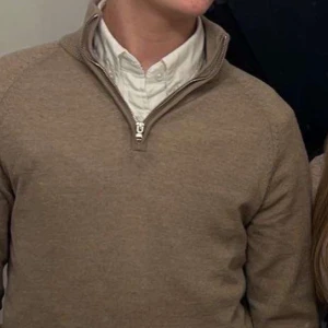 Beige half zip - En beige half zip från Dressmann. Använd 1 gång annars har den mest hängt på en galge där av en lite töjning vid axeln ( sista bilden) men inget större fel. Tröjan är i bra skick. 