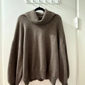 Brun polotröja i kashmir från Davida - Mysig brun polotröja från Davida i kashmir. Tröjan har oversized passform, ribbade muddar och en stor, vikt polokrage. Perfekta färgen inför höst och vinter!!