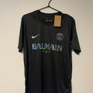 Svart PSG x Balmain fotbollströja Nike - Säljer en PSG Balmain fotbollströja. Kortärmad modell i lätt och funktionellt material, perfekt för vardagen eller när du sportar. 