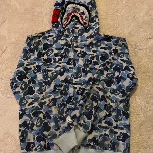 Bape Hoodie - En riktigt fin Bape hoodie i perfekt skick knappt andvänd, denna hoodie är för nån som vill testa y2k stilen om de så är denna perfekt för dig, hör av er om ni är intresserade 
