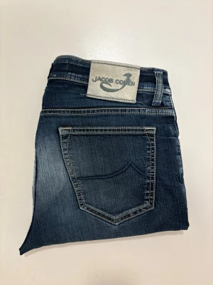 Blåa Jacob Cohen jeans - Marinblåa Jacob Cohen jeans //  Modell:620 //  Storlek 34 //  Mått  Midja bredd 44cm  Längd 100cm Innerben längd 73cm  Lårvidd 28cm  Benöppning 21cm  Mycket bra skick endast en liten slitning på baksidan som syns på bilderna //  Skriv vid minsta fråga eller fundering🤝
