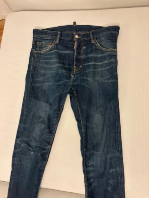 Dsq2 jeans med slitningar - Dsq2 jeans med slitningar utan skador, bra skicka, med 24/7 logga på baksidan, storlek 46, kan gå ner i pris vid snabbaffär.