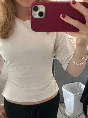 Vit croppad t-shirt i bomull - En enkel och stilren vit croppad t-shirt med rund hals och korta ärmar. Tillverkad i mjuk bomull som känns skön mot huden. Perfekt till jeans eller kjol för en clean look.