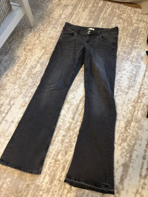 Lågmidjade bootcut jeans - Säljer dessa superfina Lågmidjade bootcut, jeansen med knapp-detaljer på fickorna från Gina Young! Endast använda en gång och den enda defekten är att de är uppsprättade nere på enda sidan för att de ska bli lite längre. I storlek 168, så skulle säga att de passar en storlek S.😙😙