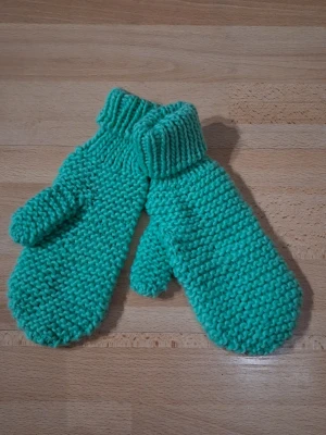 Turkosa stickade vantar - Säljer ett par handstickade vantar i en härlig turkos färg. Vantarna har en grovstickad struktur och ribbstickad mudd vid handleden. Perfekta för att hålla händerna varma under kalla dagar.