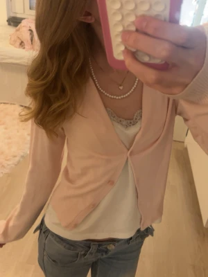 Ljusrosa kofta - Söt ljusrosa kofta. Tröjan har långa ärmar och är gjord i ett tunt, mjukt material som passar perfekt till lager-på-lager. Enkel och stilren design som är lätt att matcha med olika outfits.