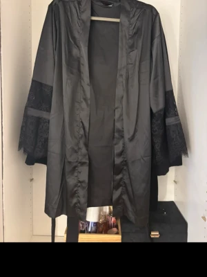 Svart morgonrock med spets - Snygg satin morgonrock med spets. Använd 2 gånger med skicket är som oanvänd. 