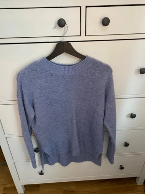 Stickad tröja - En superfin blå stickad tröja från Vero Moda. Den är lite längre bak och har slits. Storlek XS men kan passa både S och M