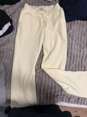Gula mjukisbyxor - Snygga ljusgula mjukisbyxor från 157 med bred resår i midjan och snörning. Byxorna har en relaxed passform och är tillverkade i mjukt material som känns skönt mot huden. Perfekta för chill dagar eller när du vill vara extra bekväm. Storlek S och använda typ 2 gånger så är som nya!