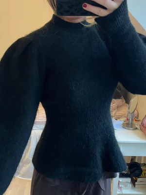 Svart puffärm stickad tröja - svart stickad tröja med puffärmar och figurnära passform. Alpackablandning