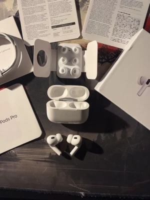 Apple AirPods Pro 2 USB-C - Säljer ett par vita Apple AirPods Pro med laddningsetui, extra silikonpluggar och originalförpackning. Hörlurarna har en stilren, kompakt design och levereras med USB-C laddkabel och manualer. Perfekta för dig som vill ha grymt ljud och smidig anslutning 