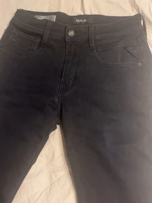 Svarta slim fit jeans från Replay - Svarta jeans från Replay med slim fit-passform och klassisk femficksdesign. Jeansen har diskret logga på fickan och är gjorda i ett stretchigt material för extra komfort. Snygga detaljer och modern look som passar till många stilar.