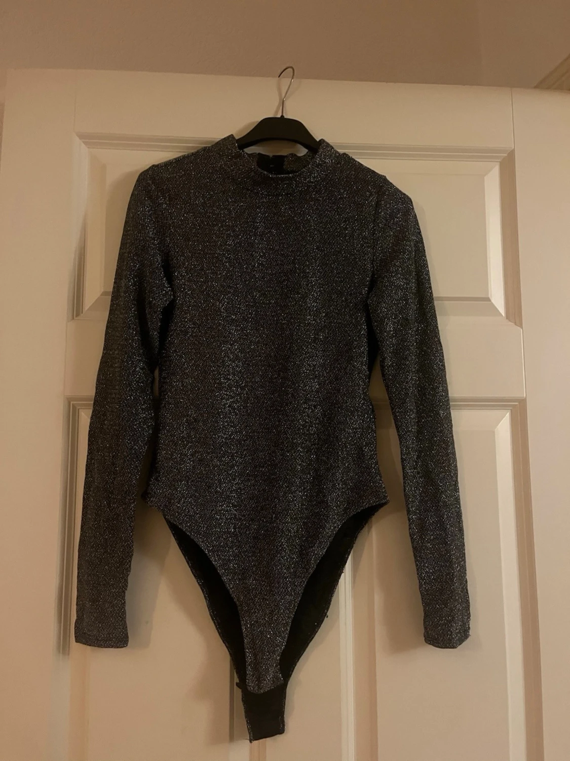 Glittrig svart långärmad body