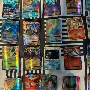 Samling Pokémonkort holografiska - Stor samling Pokémonkort med holografisk finish. Blandade motiv och färger, flera kända Pokémon som Charizard, Zapdos och Raichu. Korten har olika färgstarka illustrationer och vissa är GX eller EX-versioner. Perfekt för samlare eller Pokémonfans. Är 40 kort som är värt mycket pengar en del går för 600 och 500 
