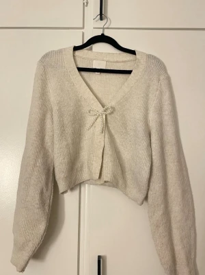 Beige kofta hm - Söt kofta med rosett detalj, mycket bra skick inga defekter 