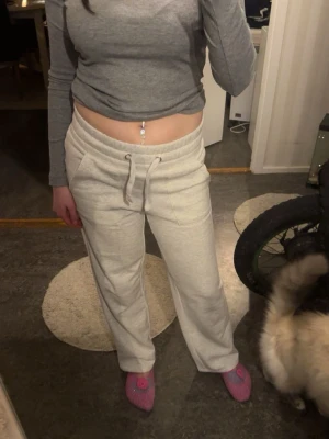 Gråa mjukisbyxor  - Säljer ett par gråa mjukisbyxor med raka ben och resårmidja. Byxorna har fickor på sidorna och är gjorda i ett mjukt, bekvämt material som passar perfekt för chill dagar. Inget synligt märke.