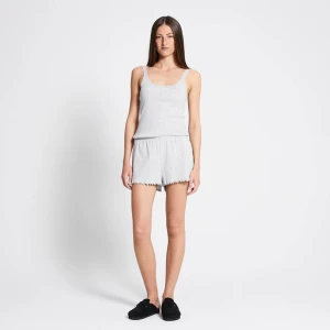 Ljusgrå ribbade shorts med volangkant - Supermjuka ljusgrå shorts med ribbad struktur och söt volangkant nertill. De har en relaxed fit och elastisk midja för extra komfort. Perfekta för chill dagar eller som mysplagg hemma.