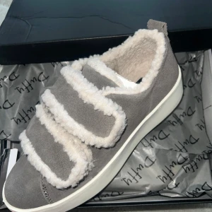 Fodrade sneakers från Duffy - Mysiga grå sneakers från Duffy med fluffigt teddyfoder och breda kardborreband. Populära och slutsålda, helt nya