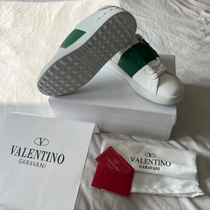 Valentino Garavani Open sneakers vit/grön - Valentino Garavani Open sneakers vit/grön i storlek 43. Skorna är aldrig använda. Låda, äkthetscert, dustbag och påse medföljer. AA kopior därav bra pris.