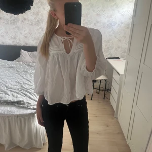 Vit blus med knyt och vida ärmar - Säljer en luftig vit blus med knyt i halsen och knappar framtill. Blusen går att staila till mycket! Ordinarie pris är 400kr den är aldrig använd 