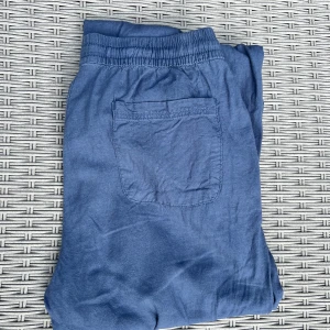 Blå linnebyxor med snörning XS - Snygga blå linnebyxor med resår och snörning i midjan. Byxorna har en avslappnad passform, raka ben och praktiska fickor fram och bak. Perfekta för varma dagar och chill outfits!!