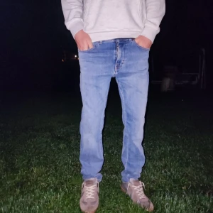 Tiger of Sweden jeans 30/32 - Snygga blå jeans från Tiger of Sweden i modellen Leon. Klassisk femficksdesign med raka ben och regular passform. Jeansen är i färgen ljusblå och har orangea sömmar. De är helt oanvända men jag säljer då de är för stora i midjan. Jeansen kommer få en fet tvätt ju mer man använder dom dom . Perfekta för dig som gillar stilrena och tidlösa jeans. Nypris: 1600