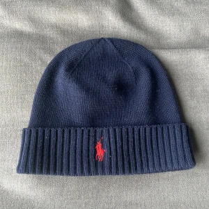 Polo ralph lauren mössa - Skön mörkblå mössa från Ralph lauren. Sparsamt använd skriv vid funderingar!